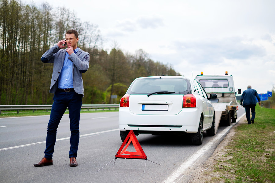 man taking phone call needing roadside assistance