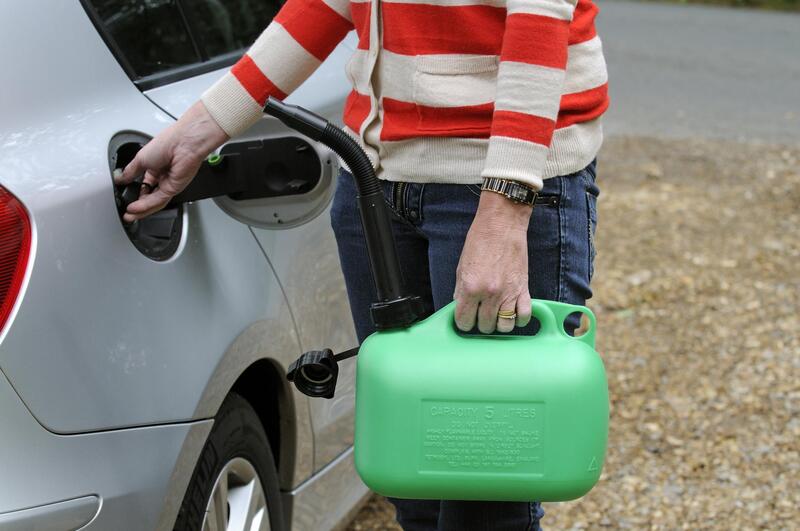 woman holding a gallon of gas